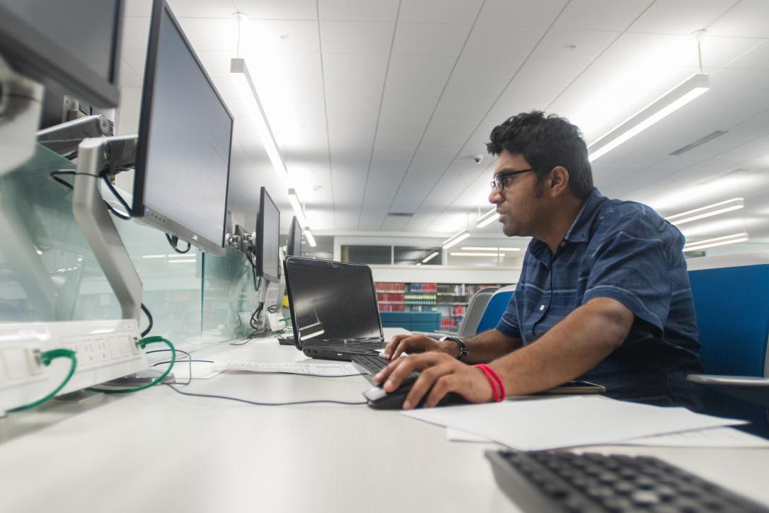 A student works on a computer in the library.